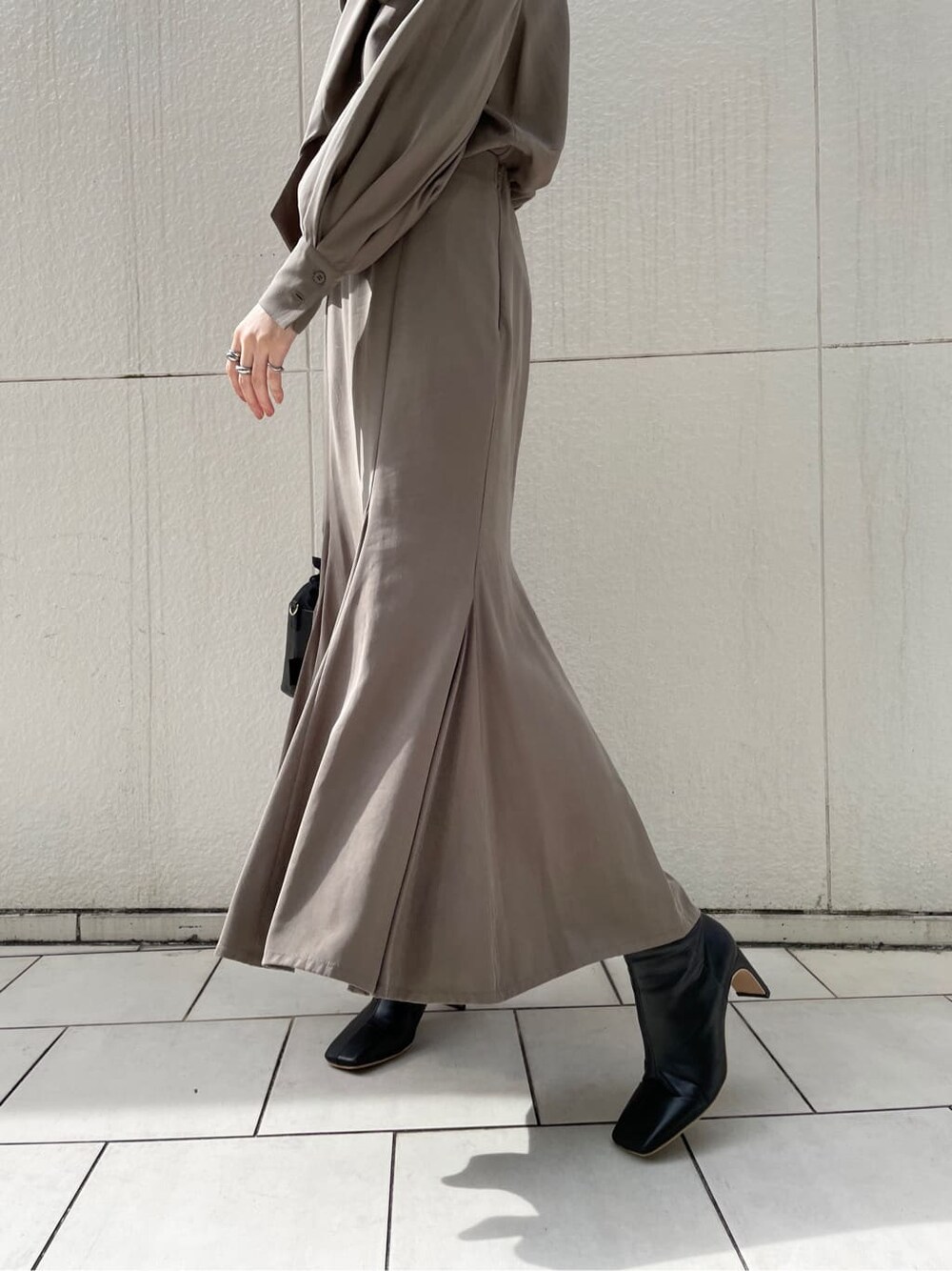 ブラック系のその他シューズ、ホワイト系のその他アウター、ブラウン系のシャツ/ブラウスを着用したレディースの冬コーディネートの4枚目の写真