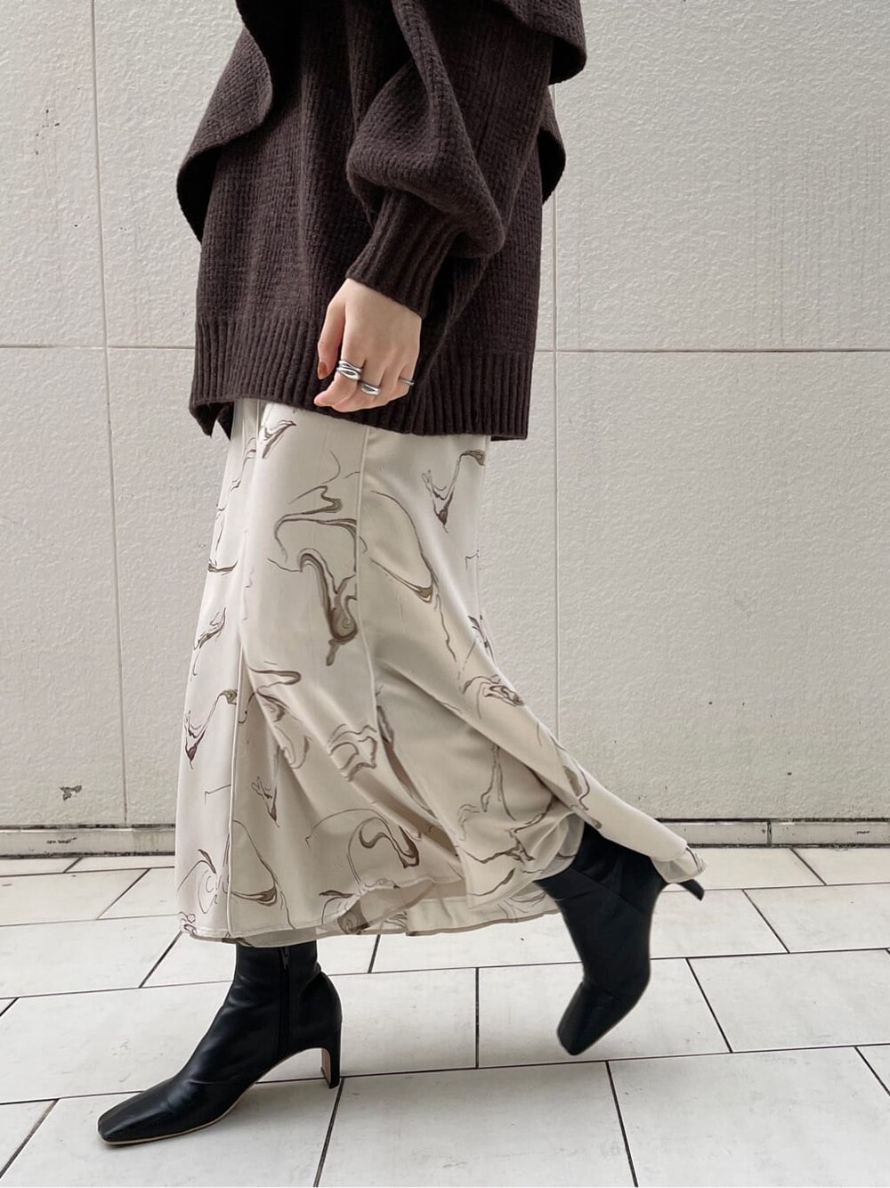 ブラック系のその他シューズ、ブラック系のハンドバッグ、ホワイト系のスカートを着用したレディースの冬コーディネートの7枚目の写真