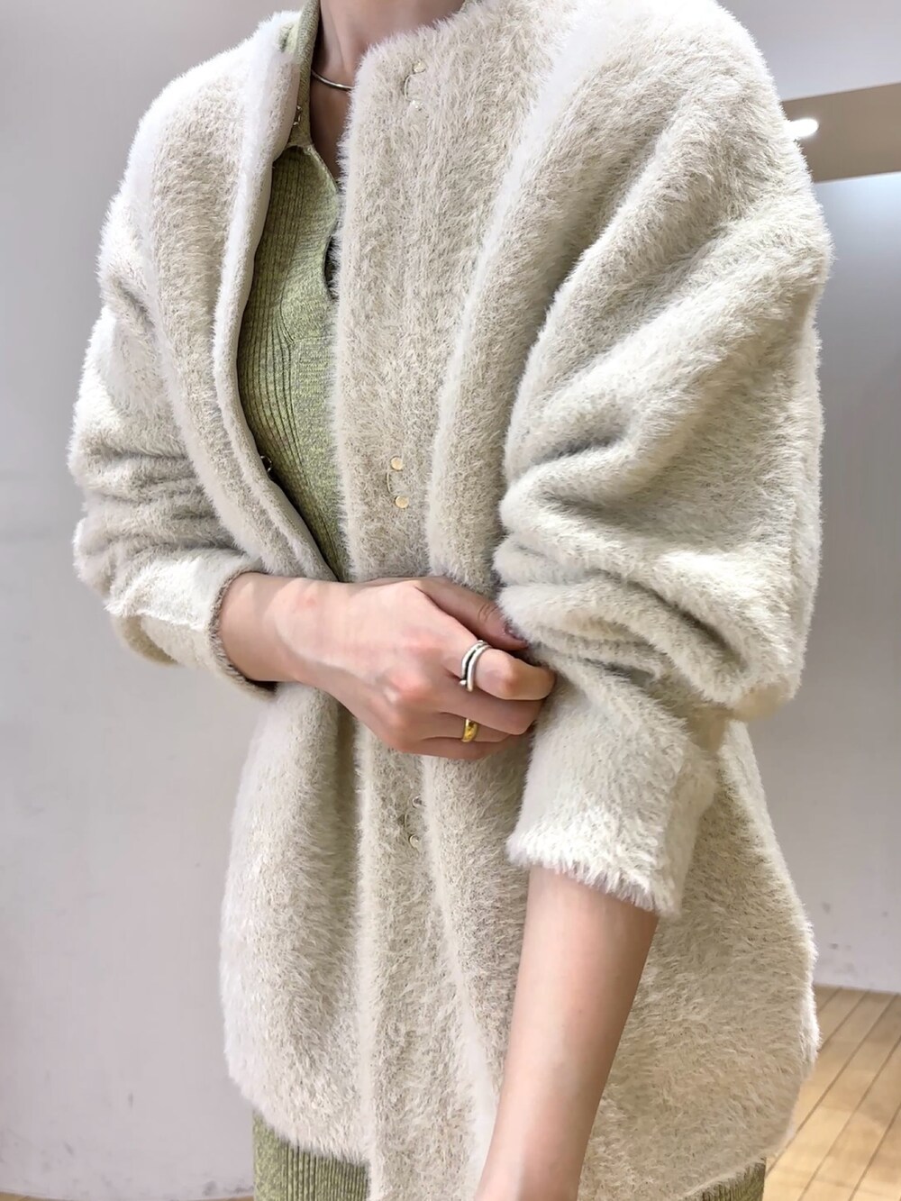 グリーン系のワンピース、シルバー系のブーツを着用したレディースの冬コーディネートの6枚目の写真