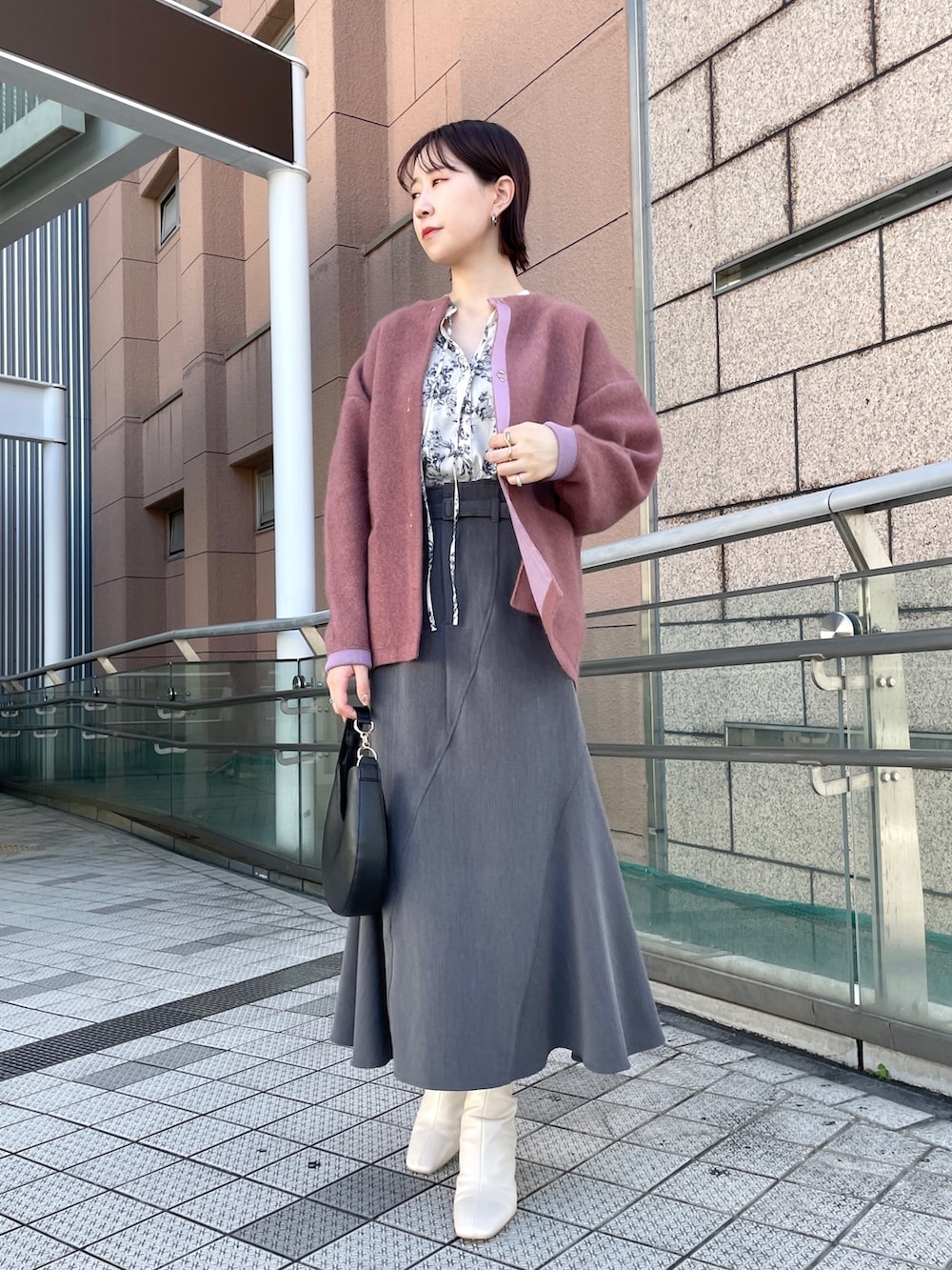 グレー系のスカート、ホワイト系のシャツ/ブラウス、ホワイト系のブーツを着用したレディースの秋コーディネートの7枚目の写真