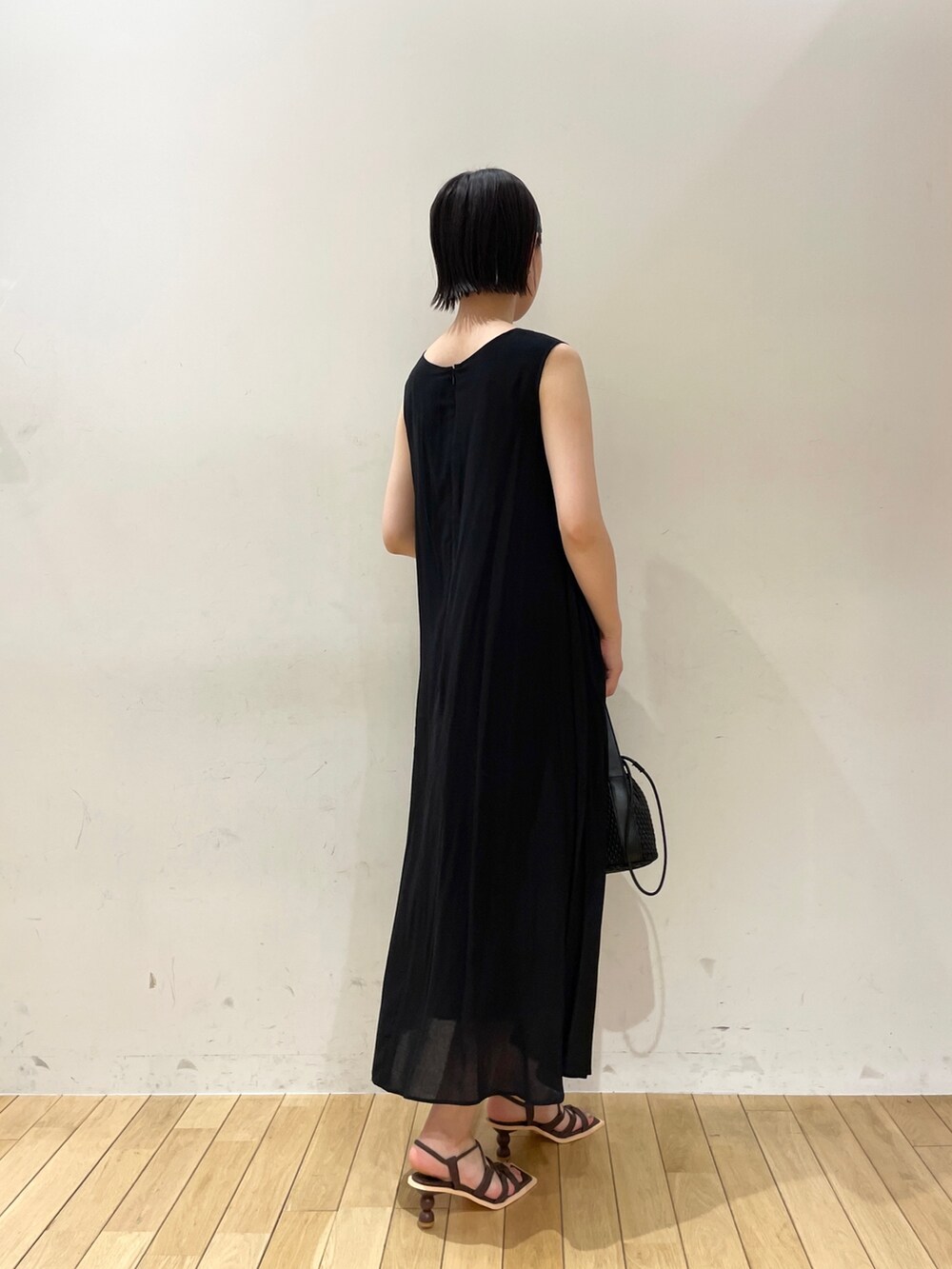 ブラック系のハンドバッグ、ベージュ系のテーラードジャケット、ブラック系のワンピースを着用したレディースの夏コーディネートの5枚目の写真