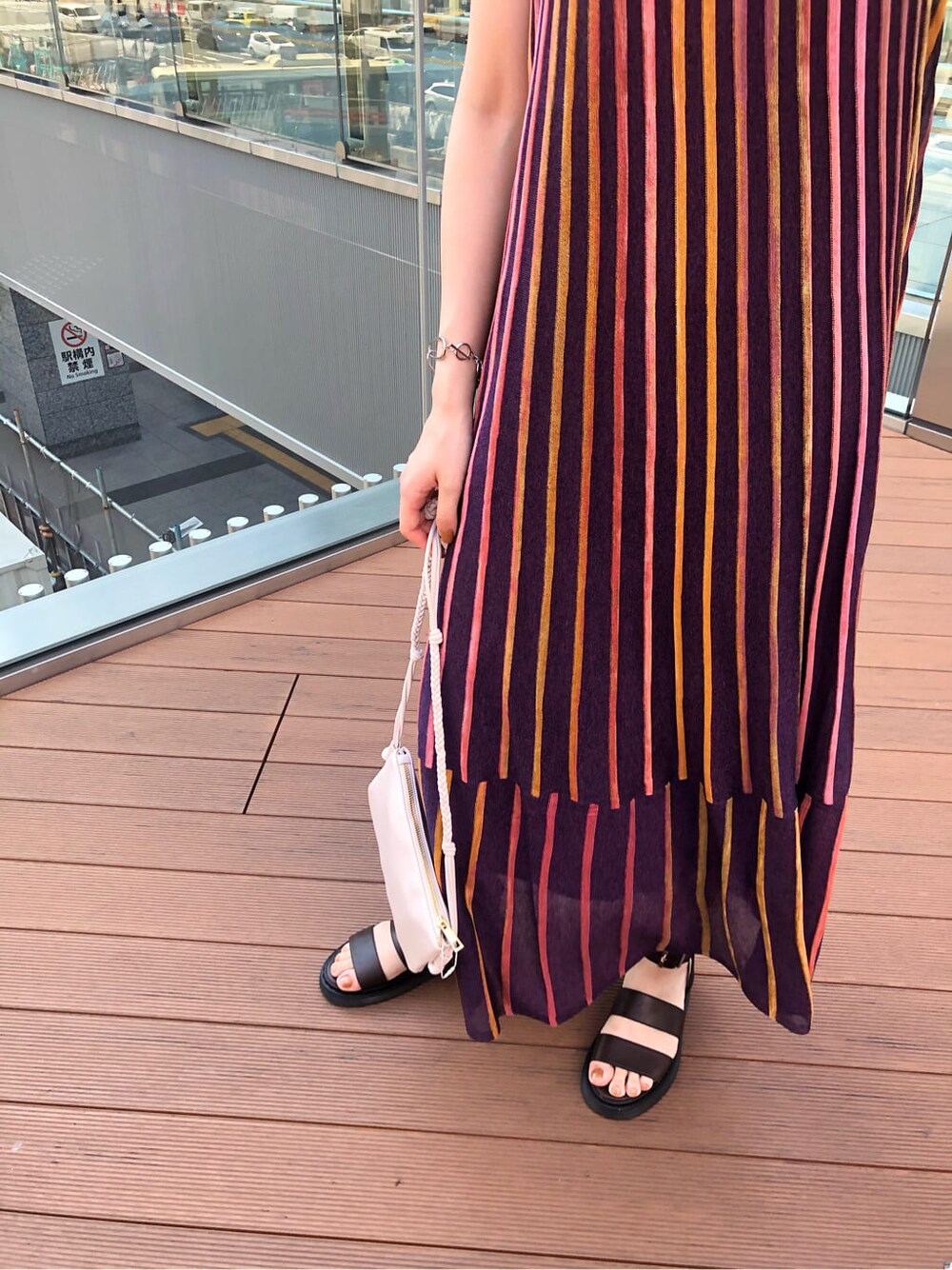 ホワイト系のショルダーバッグ、パープル系のワンピース、ブラウン系のサンダルを着用したレディースの夏コーディネートの6枚目の写真