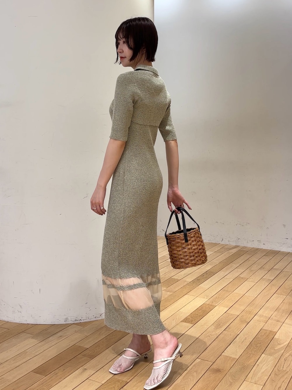 ベージュ系のワンピース、ブラウン系のハンドバッグ、ホワイト系のサンダルを着用したレディースの春コーディネートの3枚目の写真