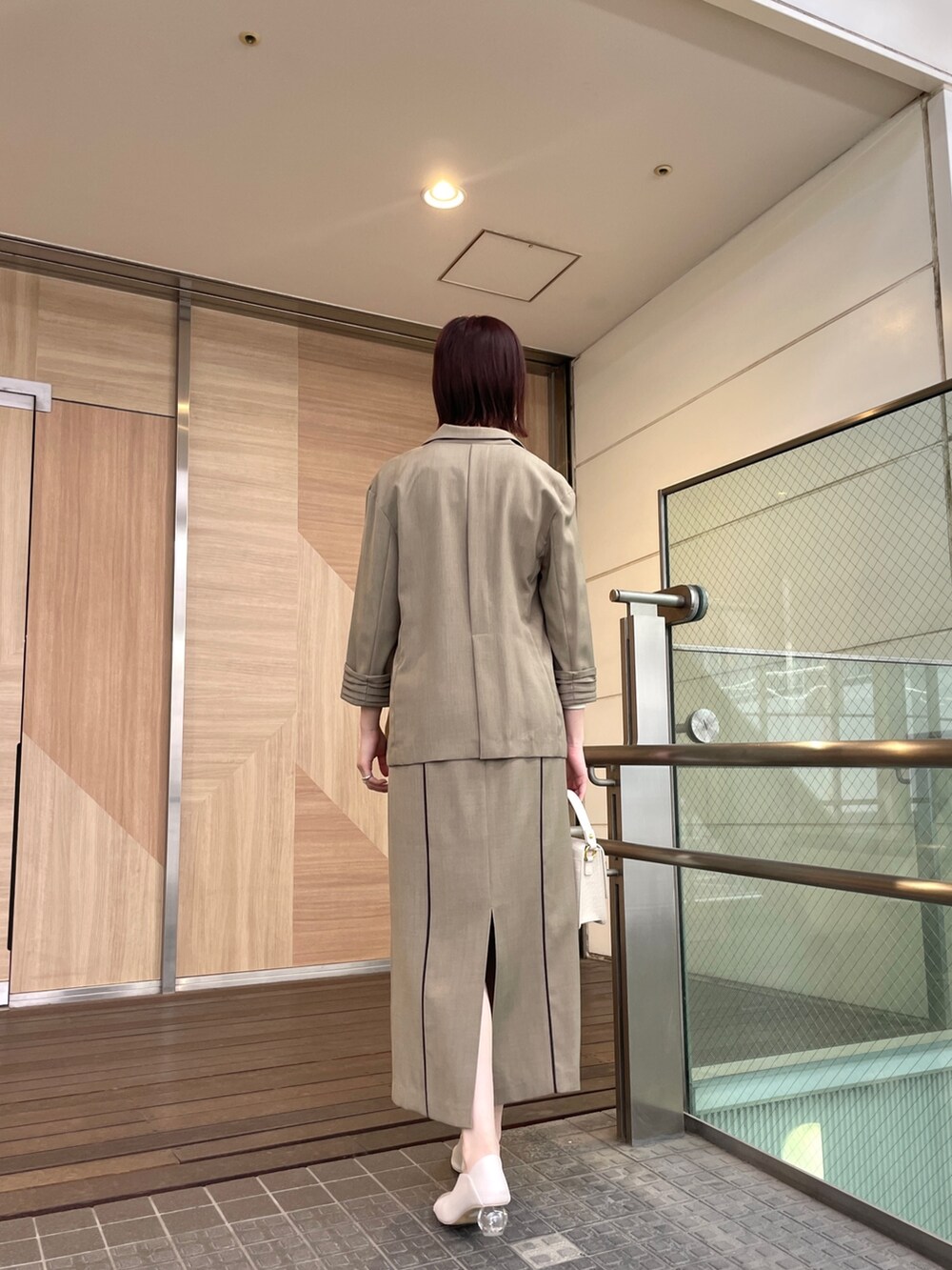 ホワイト系のパンプス、ブラウン系のテーラードジャケット、ホワイト系のニット/セーターを着用したレディースの春コーディネートの4枚目の写真