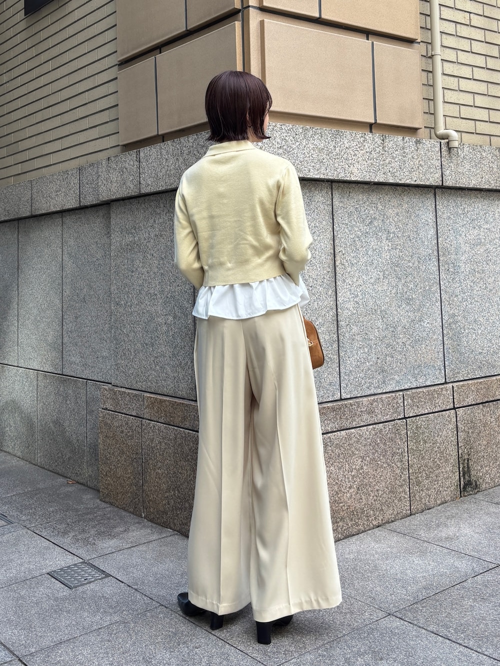 ベージュ系のその他パンツ、イエロー系のハンドバッグ、イエロー系のカーディガン/ボレロを着用したレディースの秋コーディネートの2枚目の写真