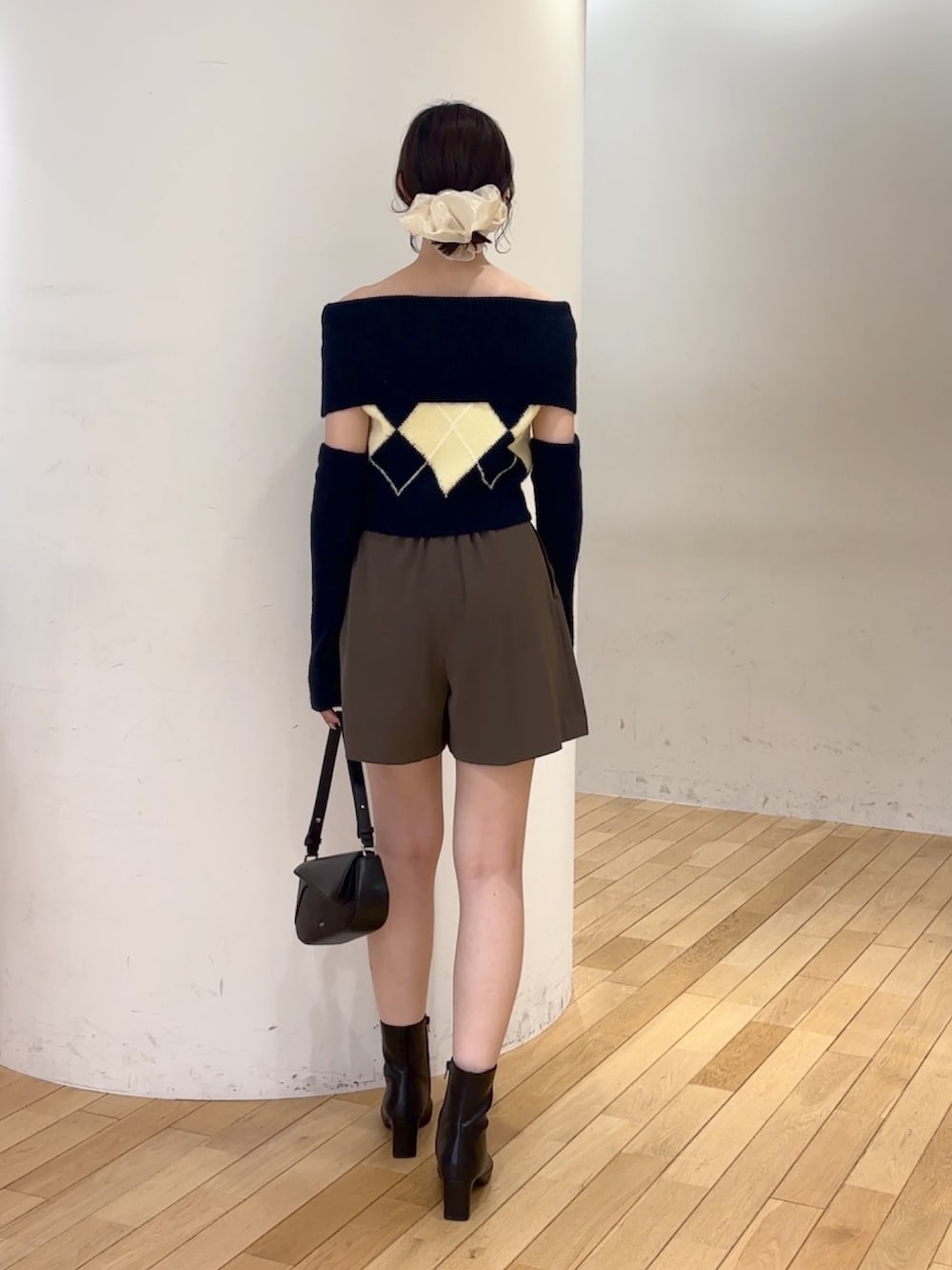 ブラウン系のその他パンツ、ブルー系のニット/セーター、ブラック系のハンドバッグを着用したレディースの夏コーディネートの4枚目の写真