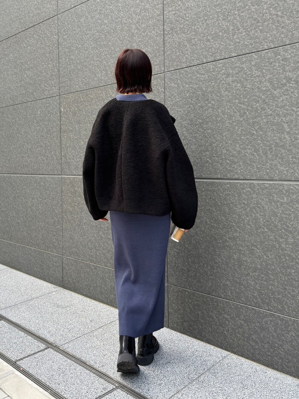 ブルー系のワンピース、ブラック系のブルゾンを着用したレディースの秋コーディネートの4枚目の写真