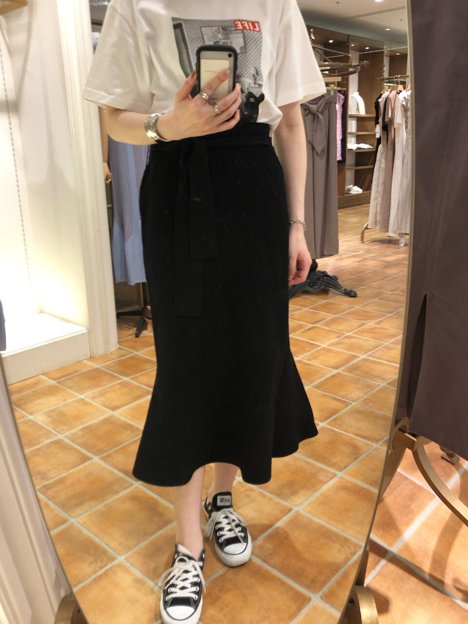 ブラック系のスカート、ブラック系のその他シューズ、ホワイト系のTシャツ/カットソーを着用したレディースの夏コーディネートの6枚目の写真