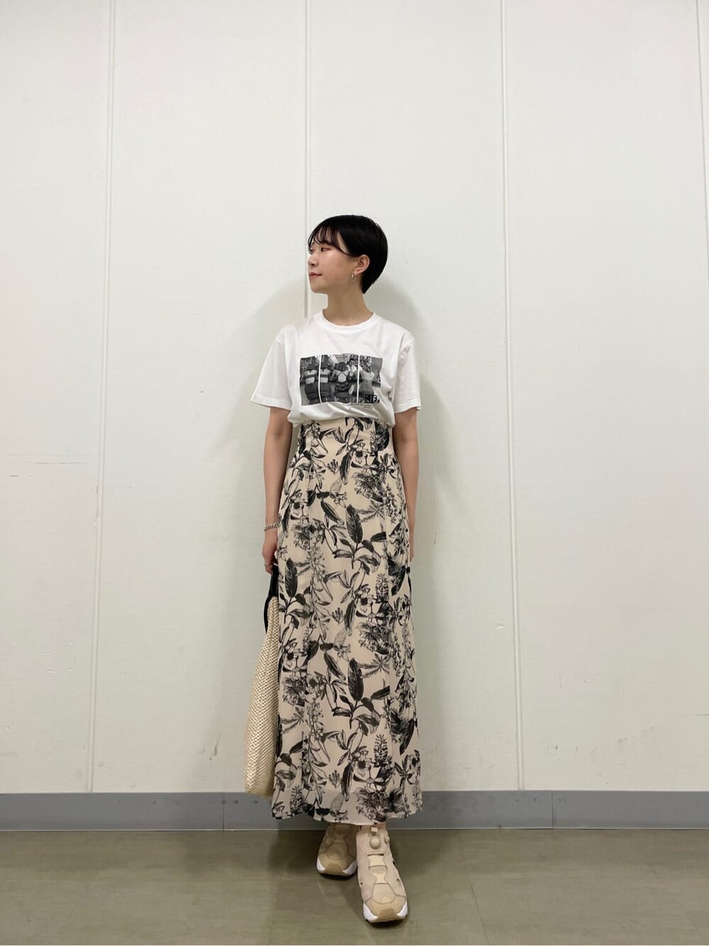 ベージュ系のスニーカー、ホワイト系のTシャツ/カットソー、ベージュ系のスカートを着用したレディースの夏コーディネートの2枚目の写真