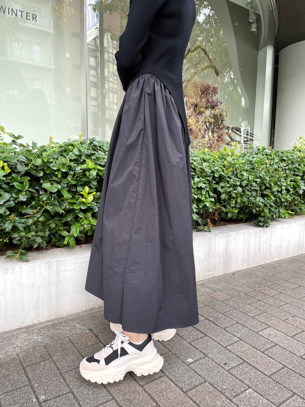 ブラック系のスニーカー、ブラック系のワンピースを着用したレディースの冬コーディネートの7枚目の写真