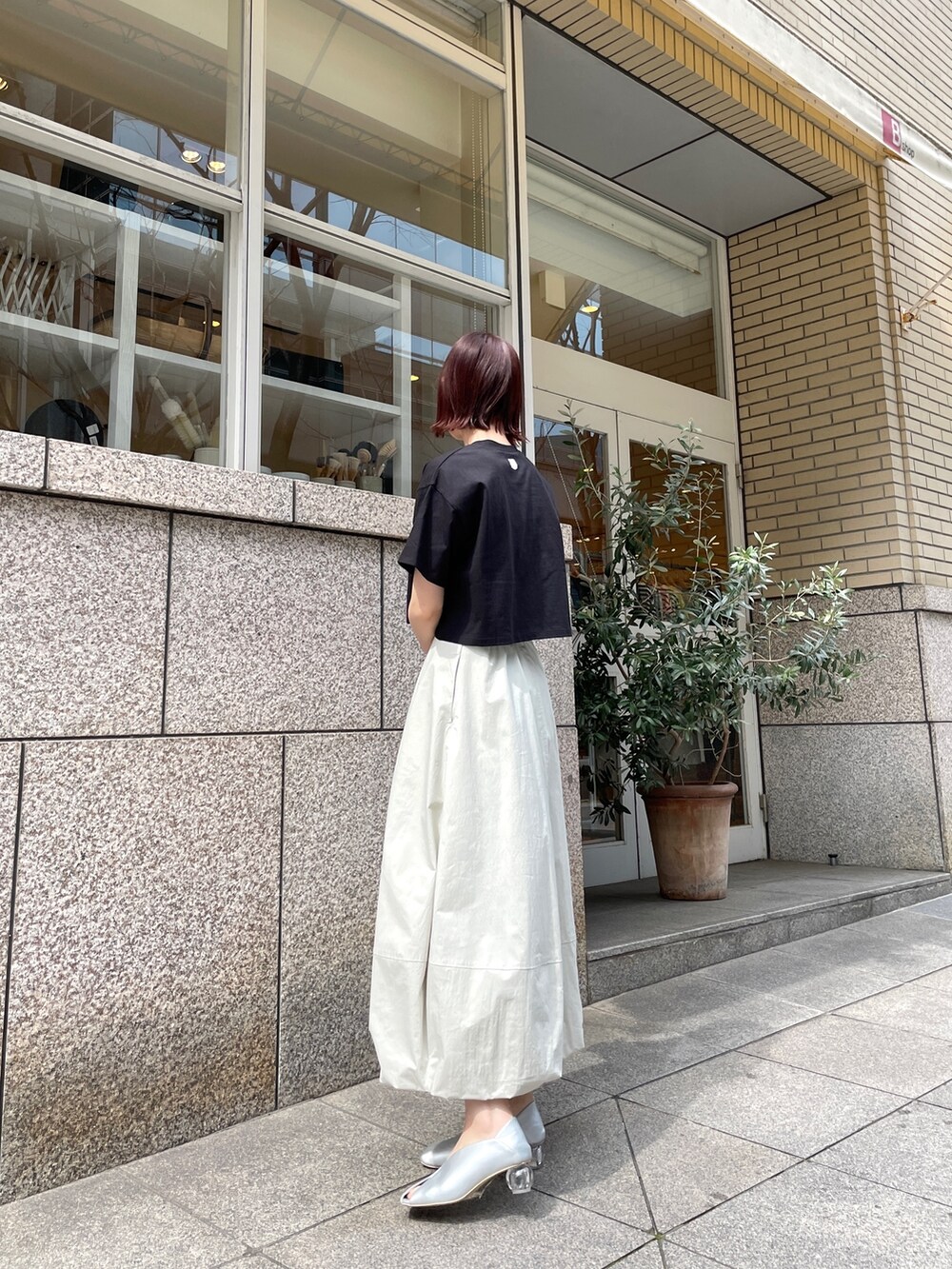 シルバー系のパンプス、ブラック系のTシャツ/カットソー、ホワイト系のスカートを着用したレディースの春コーディネートの5枚目の写真