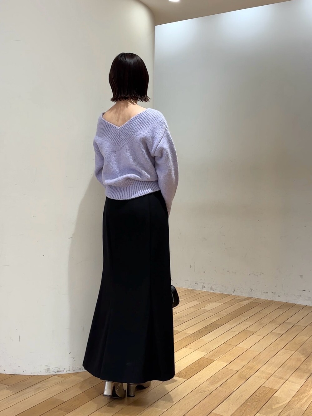 ブラック系のスカート、パープル系のニット/セーター、ブラック系のショルダーバッグを着用したレディースの冬コーディネートの5枚目の写真