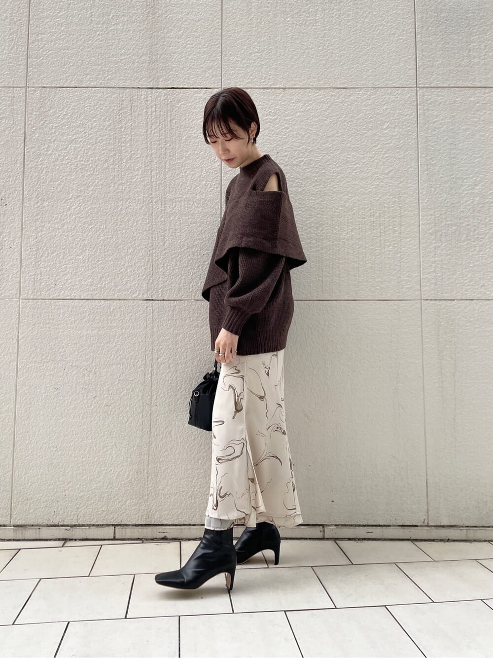 ブラック系のその他シューズ、ブラック系のハンドバッグ、ホワイト系のスカートを着用したレディースの冬コーディネートの4枚目の写真