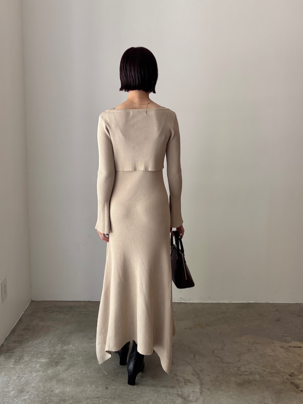 ホワイト系のワンピース、ブラウン系のボストンバッグ、ブラック系のブーツを着用したレディースの秋コーディネートの3枚目の写真