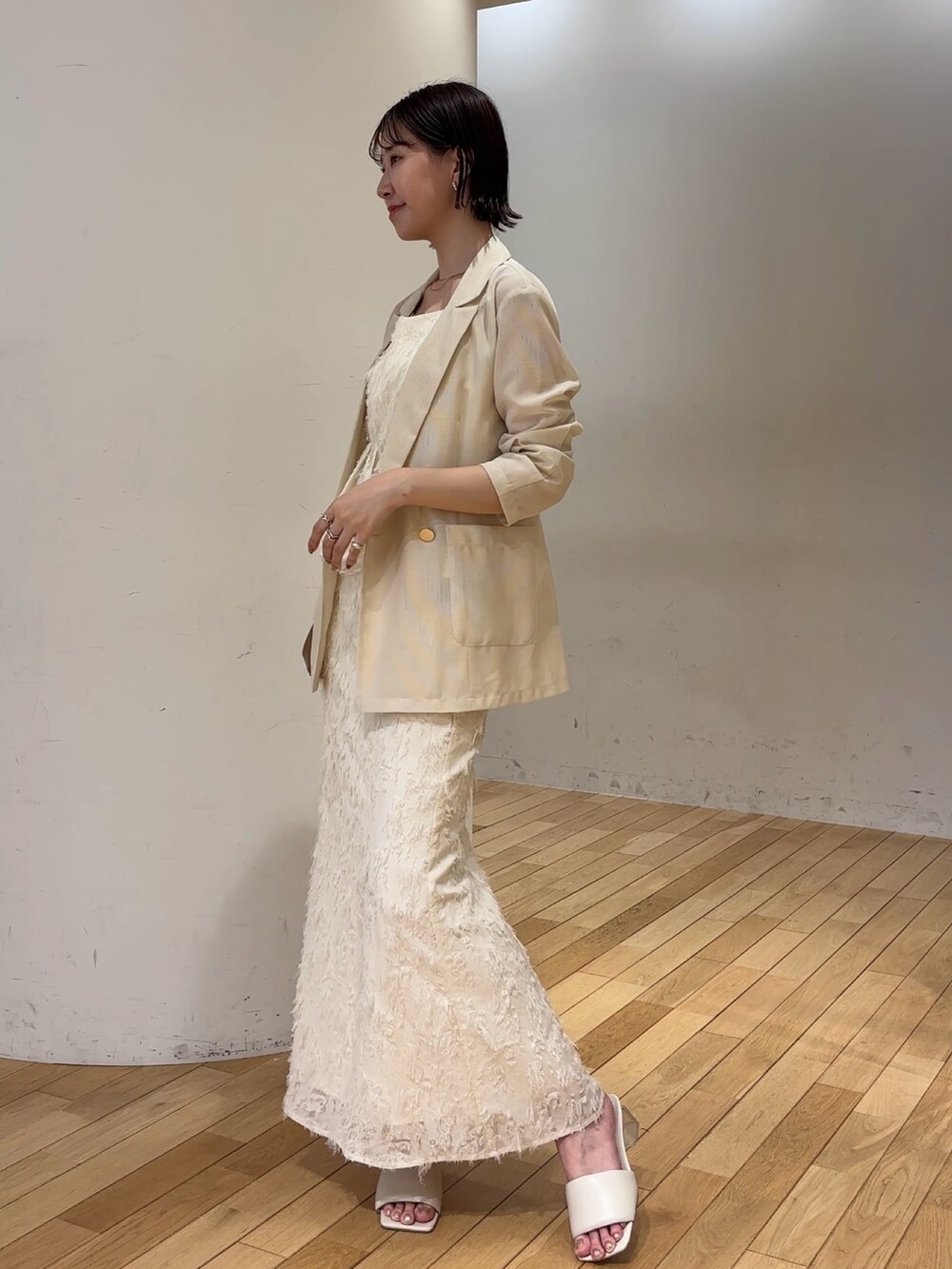 ホワイト系のスカート、ホワイト系のキャミソール、ホワイト系のテーラードジャケットを着用したレディースの夏コーディネートの3枚目の写真