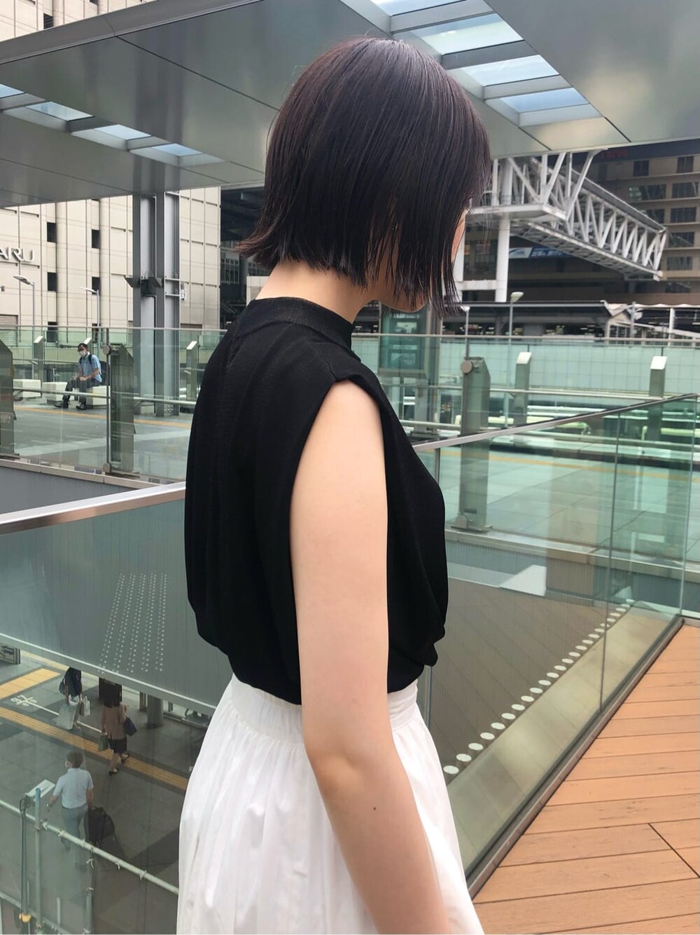 ブラック系のサンダル、ホワイト系のスカート、ブラック系のニット/セーターを着用したレディースの夏コーディネートの4枚目の写真