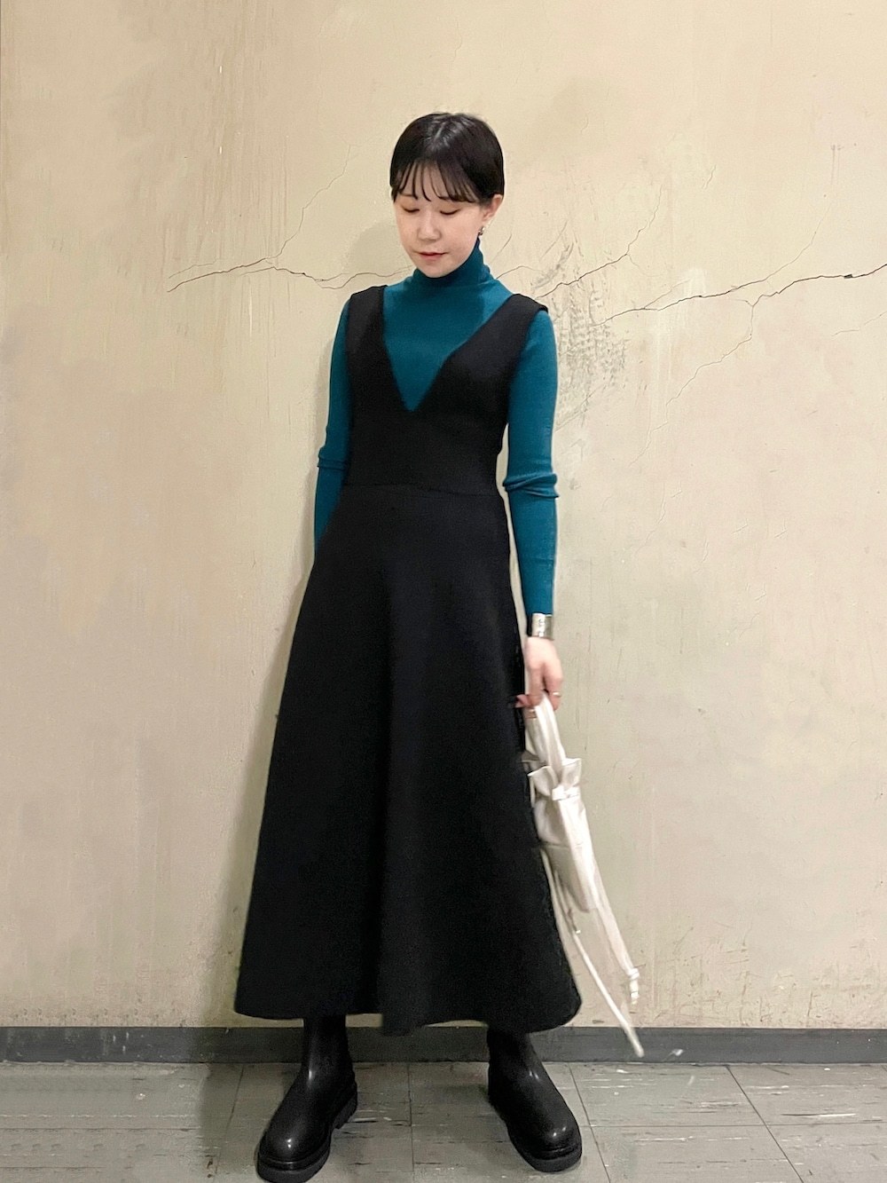 ブラック系のスカート、グリーン系のニット/セーター、ブラック系のブーツを着用したレディースの秋コーディネートの8枚目の写真