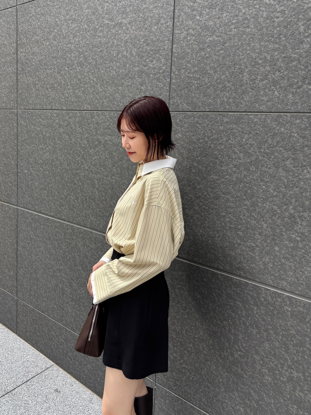 イエロー系のシャツ/ブラウス、ブラック系のその他パンツ、ブラウン系のブーツを着用したレディースの秋コーディネートの5枚目の写真