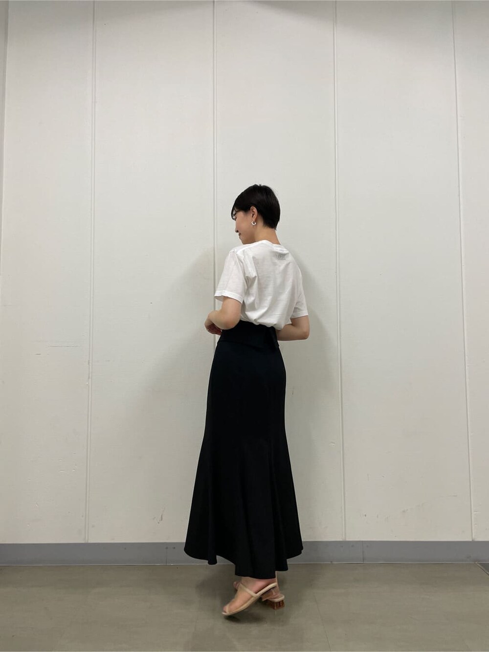 ベージュ系のスニーカー、ホワイト系のTシャツ/カットソー、ブラック系のスカートを着用したレディースの夏コーディネートの3枚目の写真