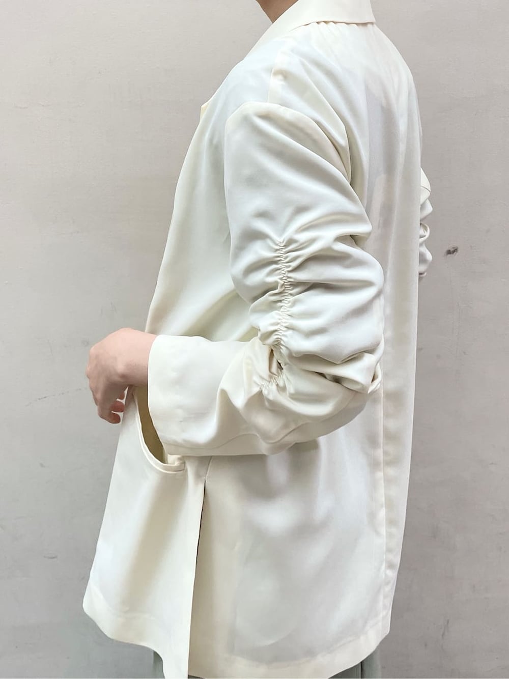 ブラック系のその他シューズ、ホワイト系のテーラードジャケット、グリーン系のワンピースを着用したレディースの冬コーディネートの6枚目の写真