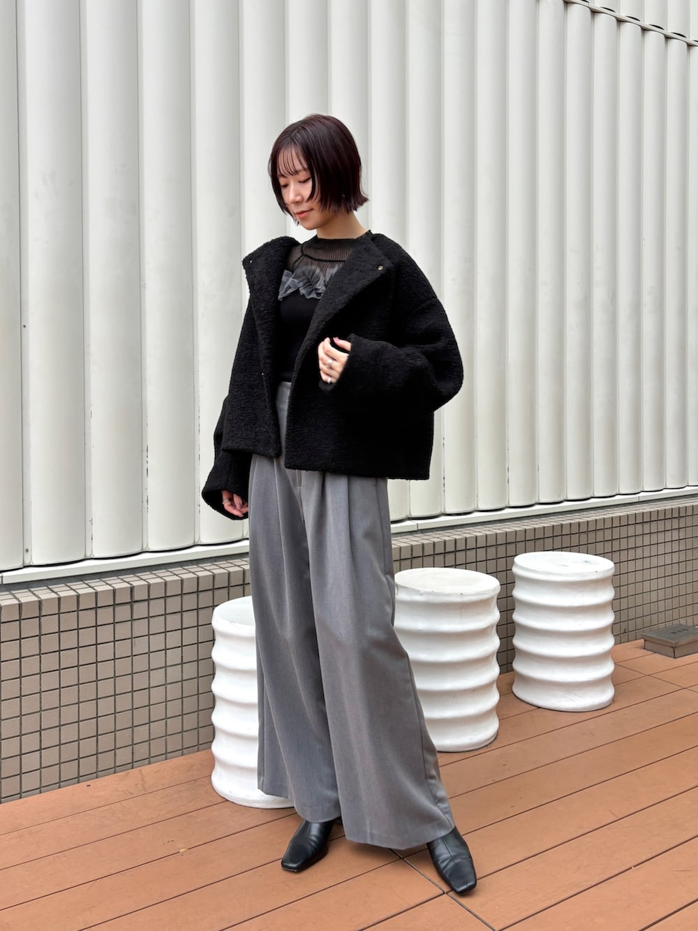 グレー系のその他パンツ、ブラック系のニット/セーター、ブラック系のブーツを着用したレディースの秋コーディネートの7枚目の写真
