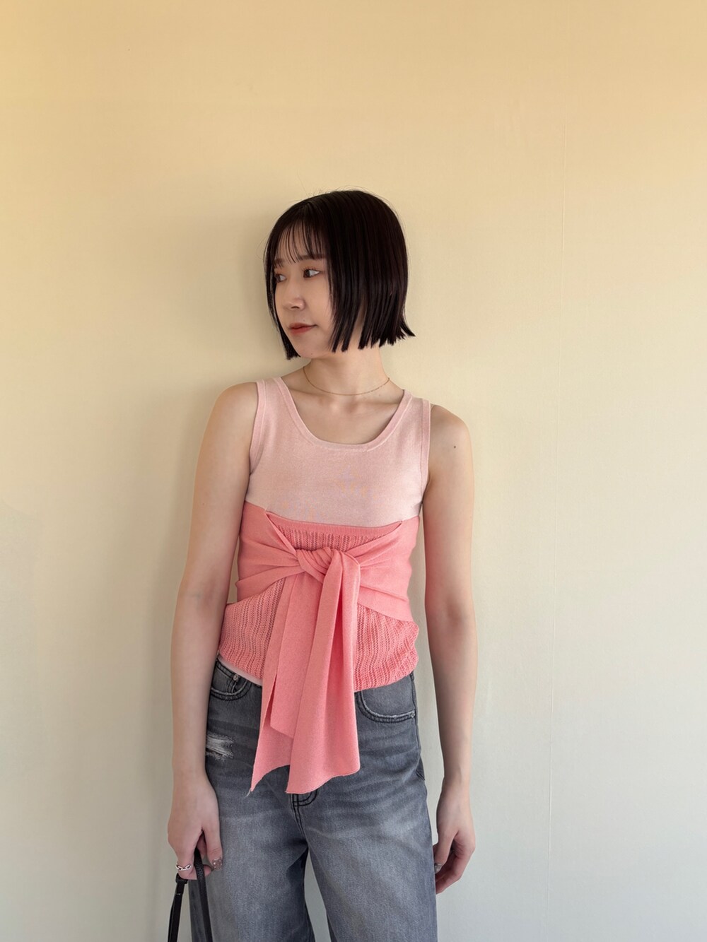 グレー系のデニムパンツ、ピンク系のニット/セーター、ブラック系のパンプスを着用したレディースの春コーディネートの4枚目の写真