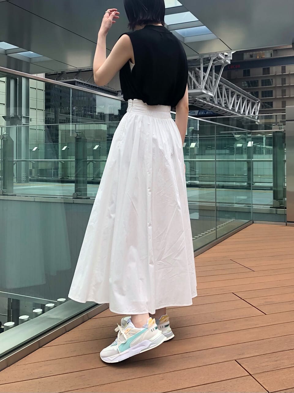 ブラック系のサンダル、ホワイト系のスカート、ブラック系のニット/セーターを着用したレディースの夏コーディネートの6枚目の写真