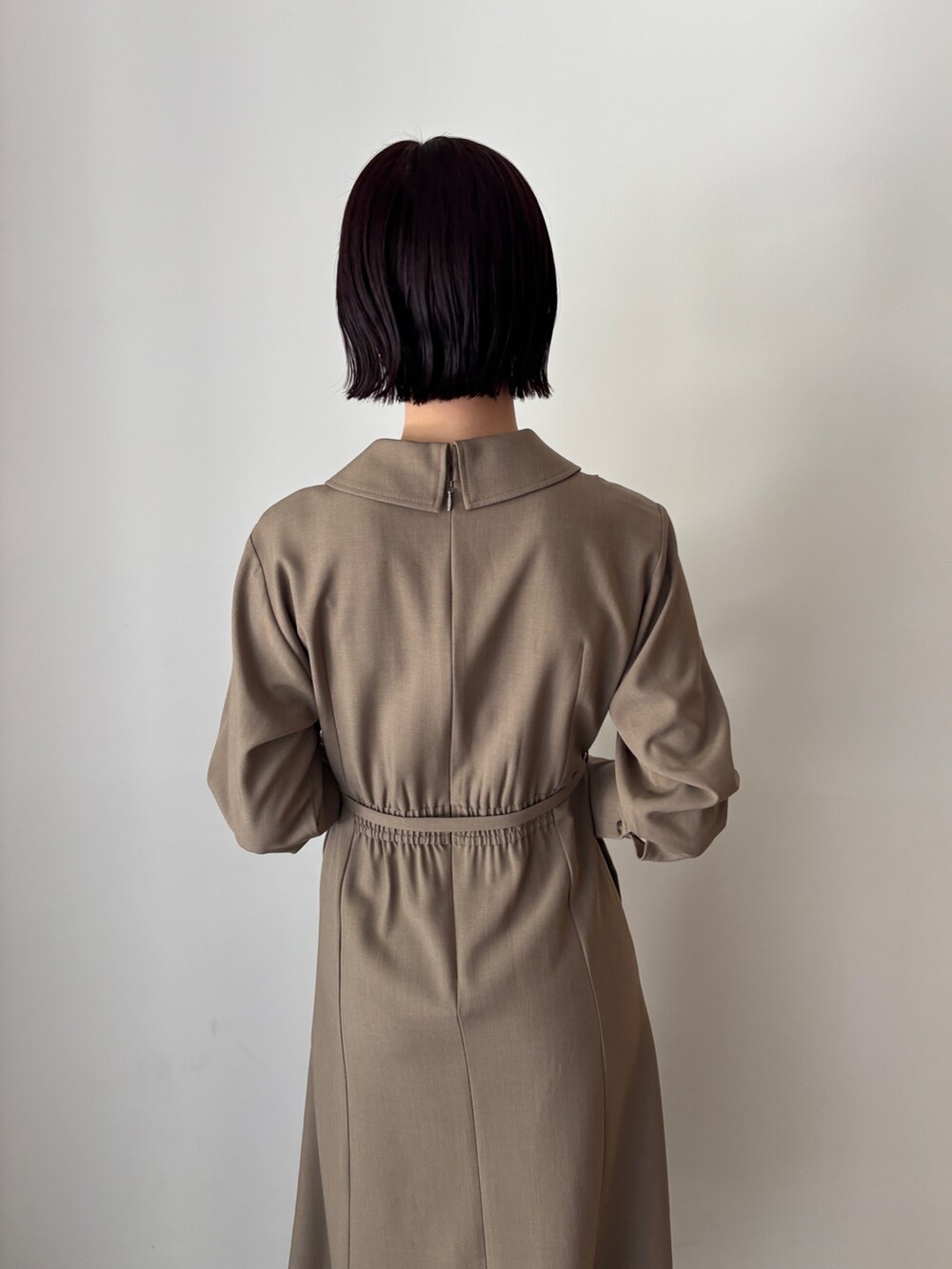 ホワイト系のワンピース、ブラウン系のハンドバッグ、ブラウン系のブーツを着用したレディースの秋コーディネートの5枚目の写真