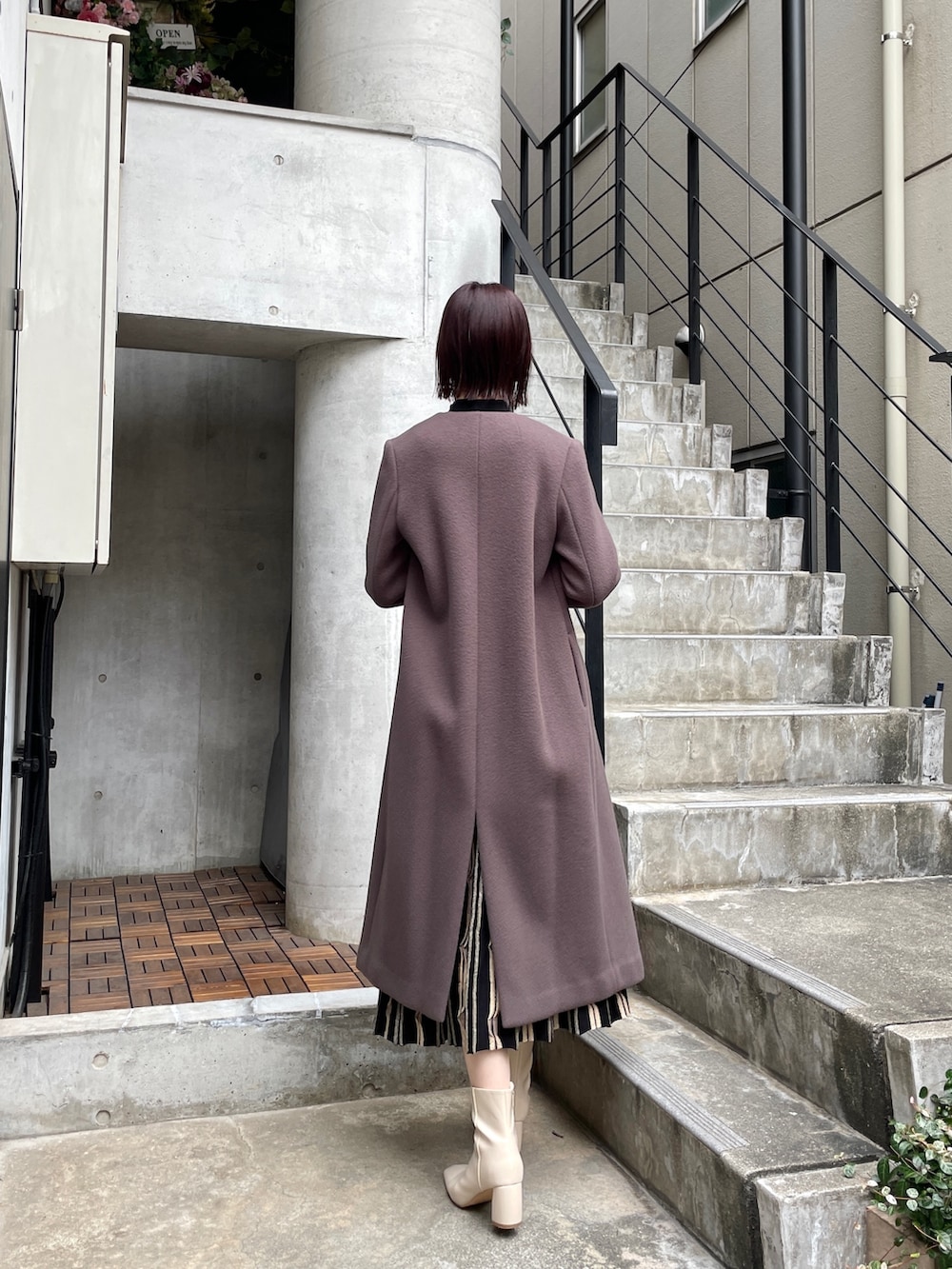 ホワイト系のブーツ、ブラック系のワンピース、グレー系のノーカラーコートを着用したレディースの冬コーディネートの7枚目の写真