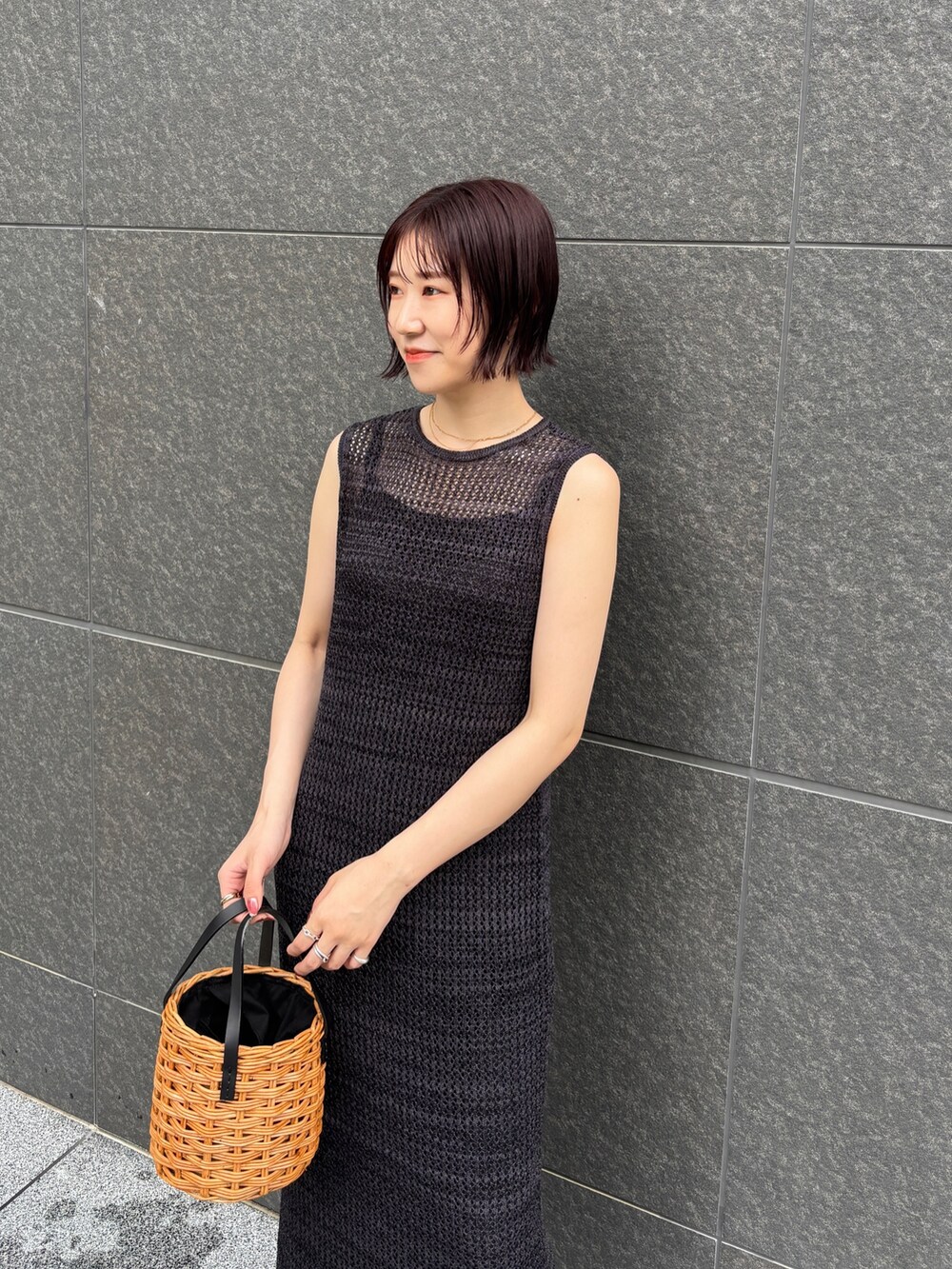 ブラック系のワンピース、ブラウン系のハンドバッグ、ブラック系のサンダルを着用したレディースの夏コーディネートの6枚目の写真