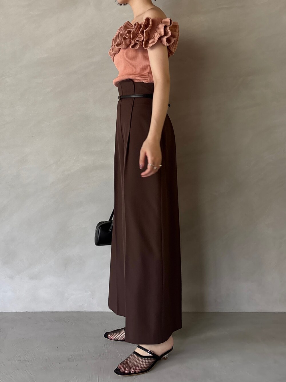 ブラウン系のその他パンツ、ブラック系のサンダル、ピンク系のニット/セーターを着用したレディースの夏コーディネートの3枚目の写真
