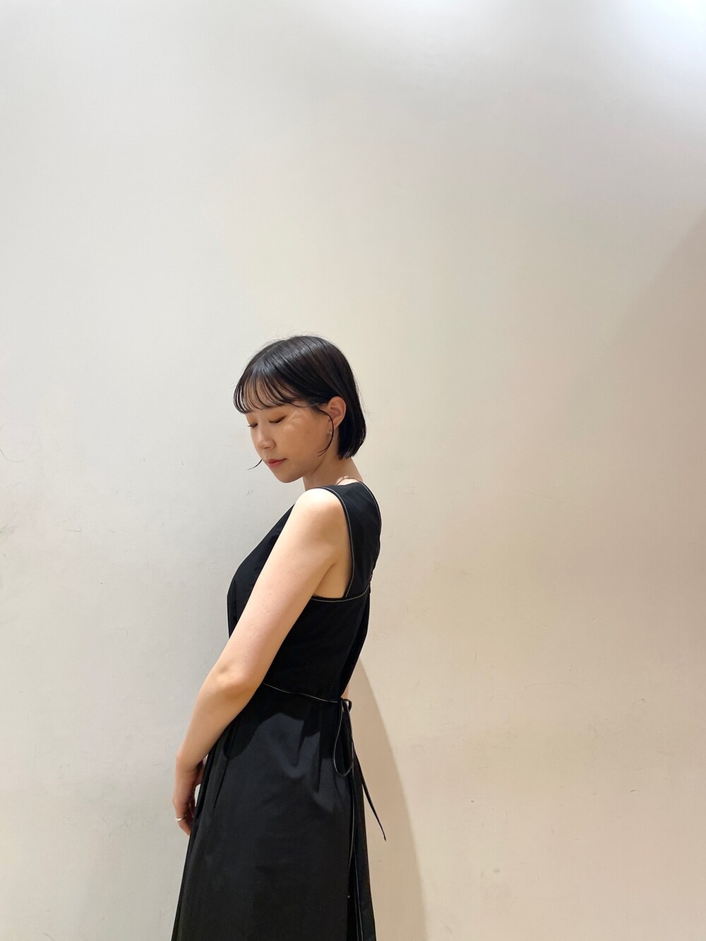 ブラック系のワンピース、ホワイト系のハンドバッグ、ホワイト系のネックレスを着用したレディースの夏コーディネートの8枚目の写真