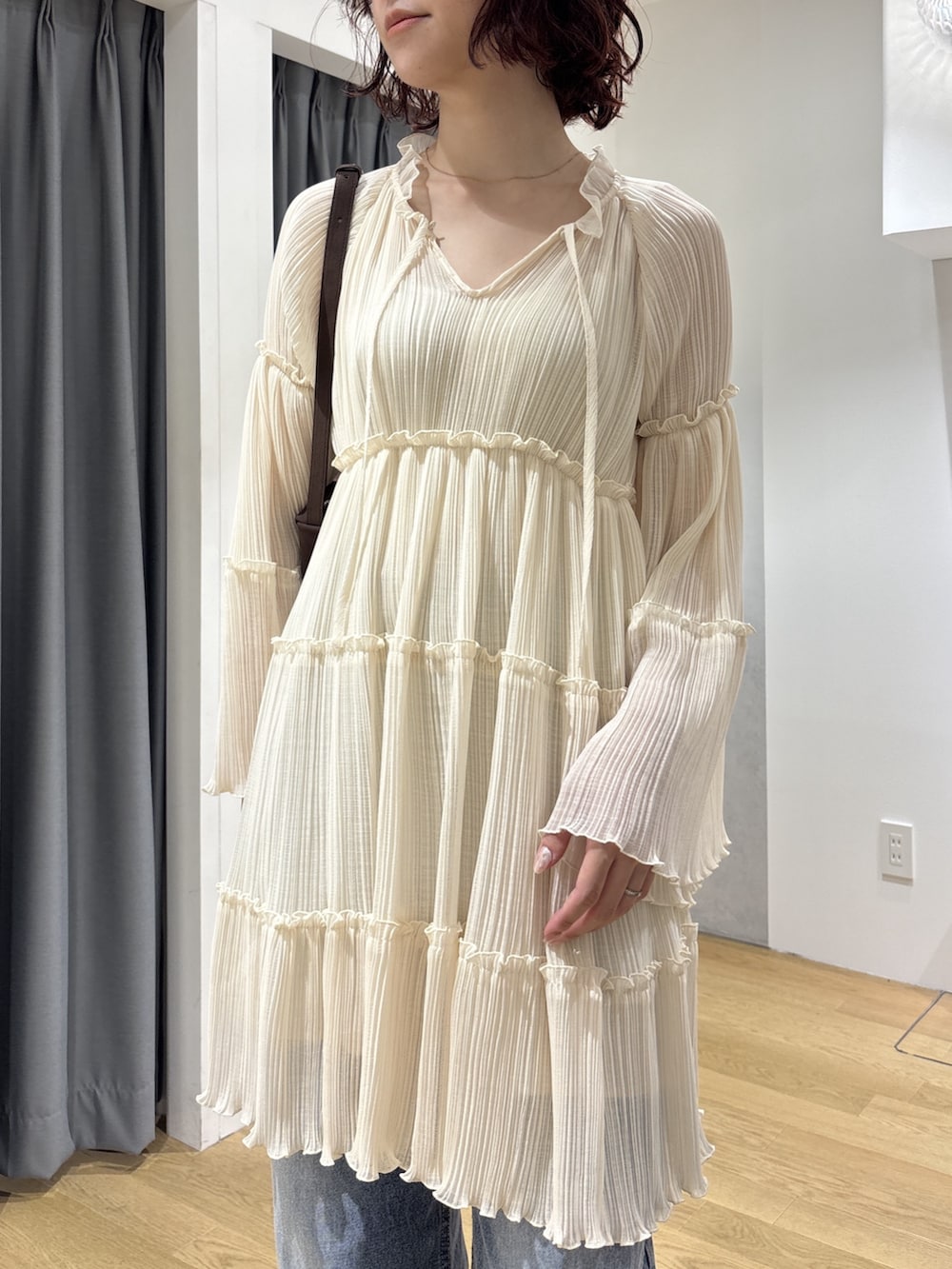 ホワイト系のワンピース、ブルー系のデニムパンツ、ブラウン系のハンドバッグを着用したレディースの秋コーディネートの5枚目の写真
