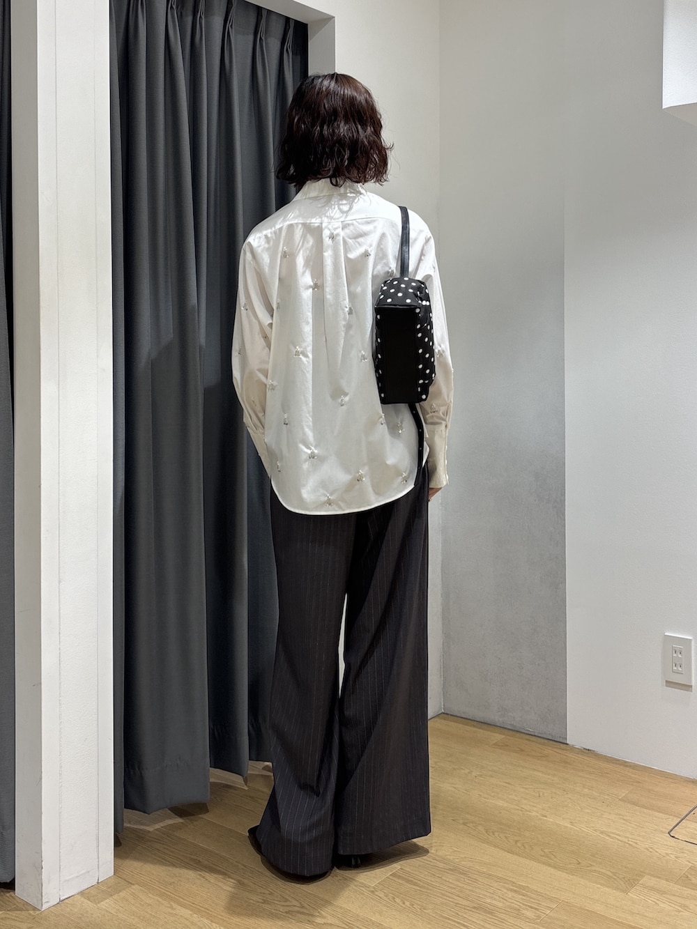 グレー系のその他パンツ、ホワイト系のシャツ/ブラウス、ブラック系のハンドバッグを着用したレディースの秋コーディネートの4枚目の写真