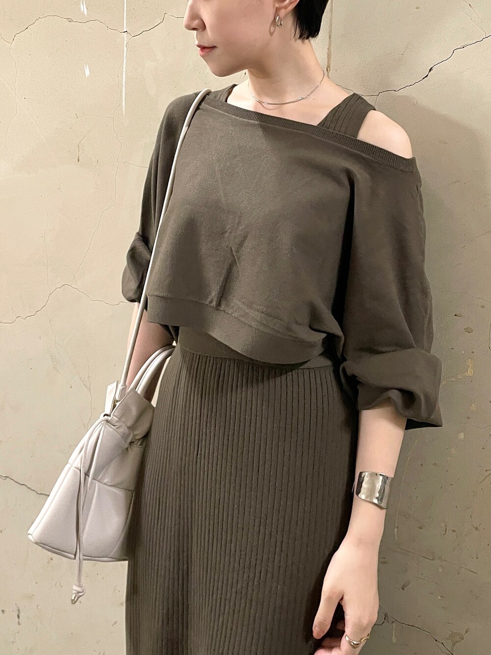 ブラウン系のワンピース、ブラック系のブーツ、ホワイト系のハンドバッグを着用したレディースの秋コーディネートの6枚目の写真