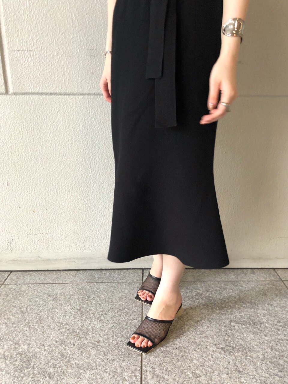 ブラック系のスカート、ブラック系のその他シューズ、ホワイト系のTシャツ/カットソーを着用したレディースの夏コーディネートの5枚目の写真