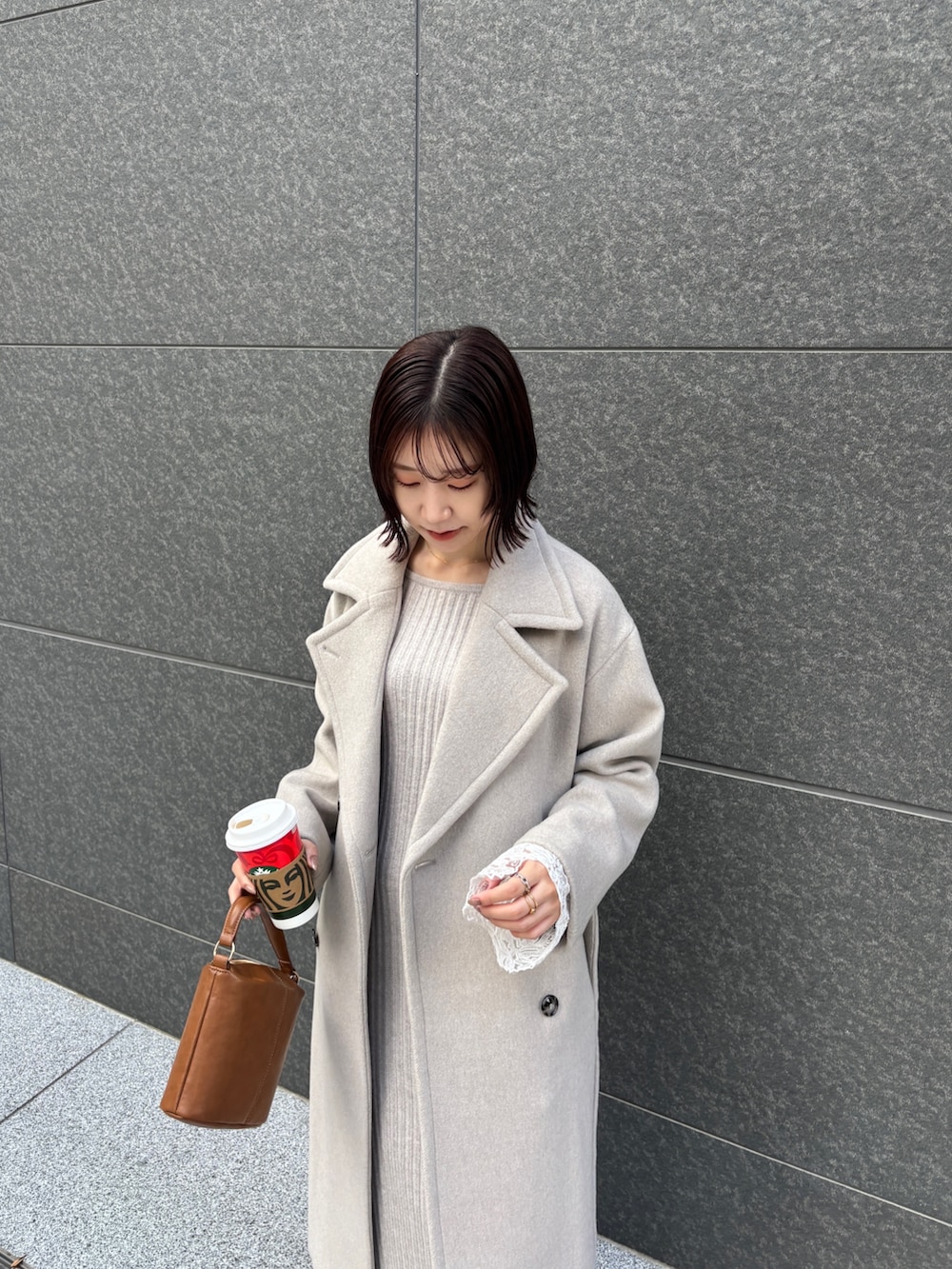 ベージュ系のワンピース、イエロー系のハンドバッグ、ブラウン系のブーツを着用したレディースの秋コーディネートの4枚目の写真