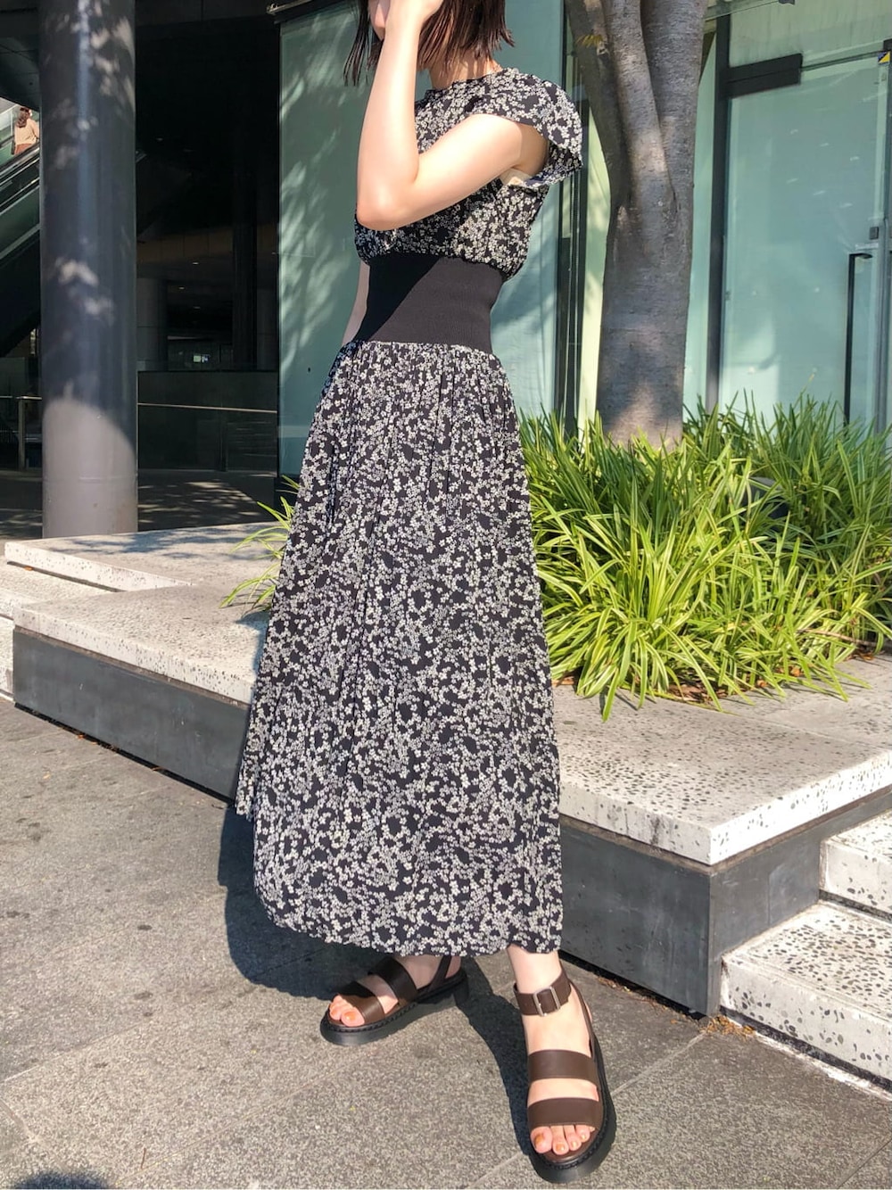 ホワイト系のショルダーバッグ、ブラック系のワンピース、ブラウン系のサンダルを着用したレディースの夏コーディネートの2枚目の写真