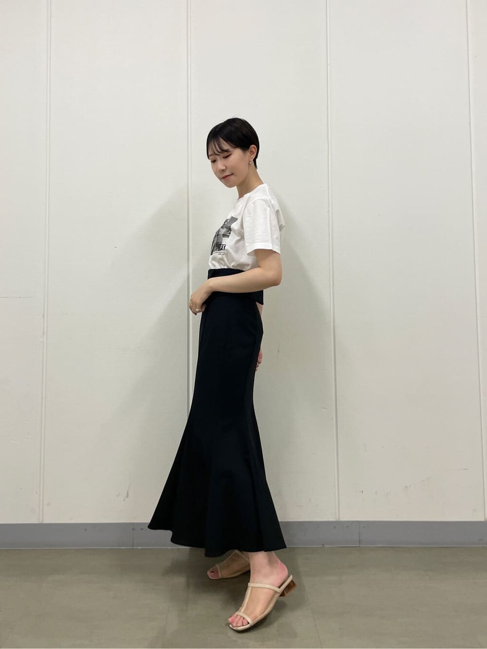 ベージュ系のスニーカー、ホワイト系のTシャツ/カットソー、ブラック系のスカートを着用したレディースの夏コーディネートの2枚目の写真