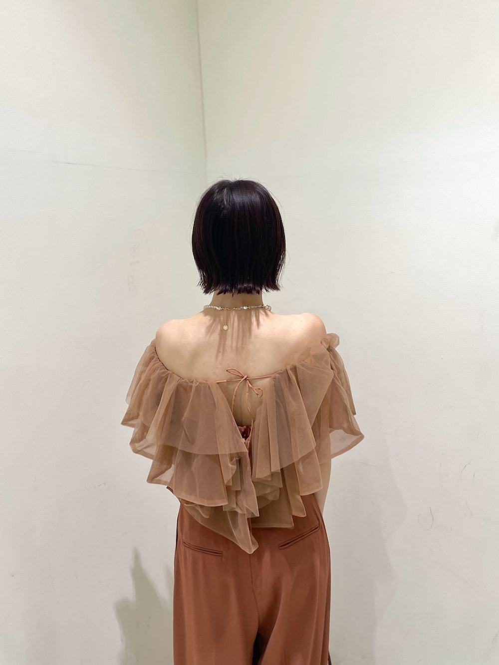 オレンジ系のパンツドレス、その他のクラッチバッグ、その他のパンプスを着用したレディースの夏コーディネートの6枚目の写真