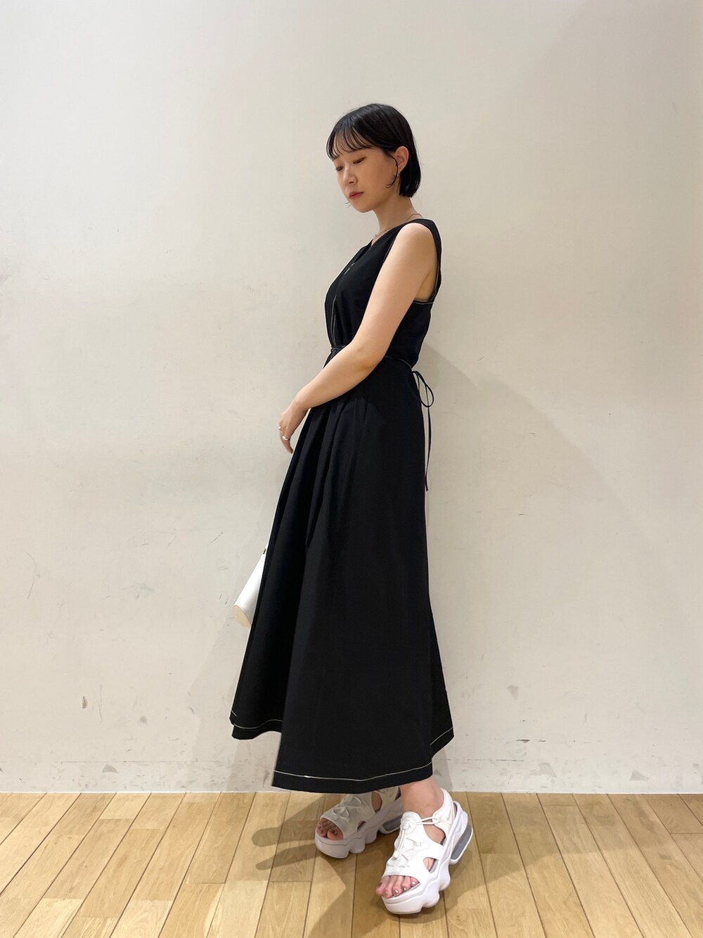 ブラック系のワンピース、ホワイト系のハンドバッグ、ホワイト系のネックレスを着用したレディースの夏コーディネートの3枚目の写真