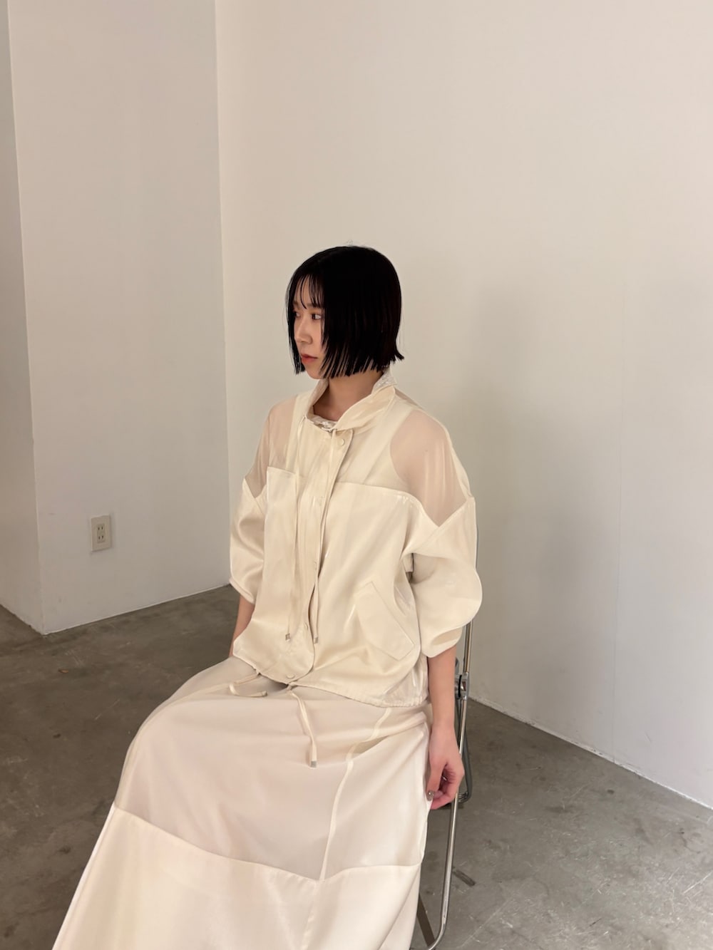 ホワイト系のスカート、ホワイト系のブルゾン、ホワイト系のタンクトップを着用したレディースの春コーディネートの4枚目の写真