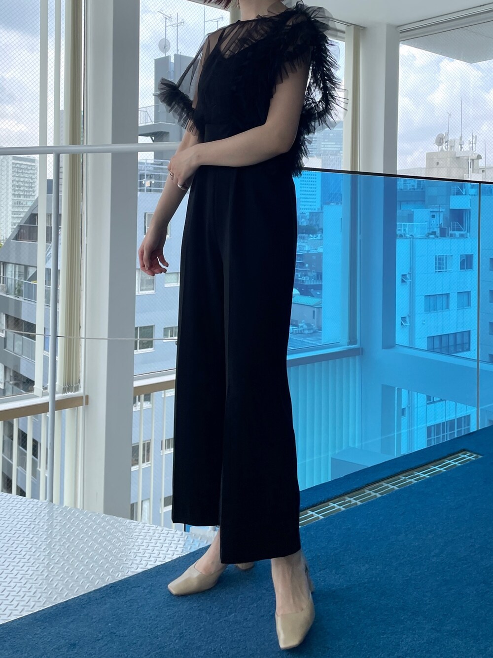 ブラック系のパンツドレス、ベージュ系のパンプスを着用したレディースの春コーディネートの4枚目の写真
