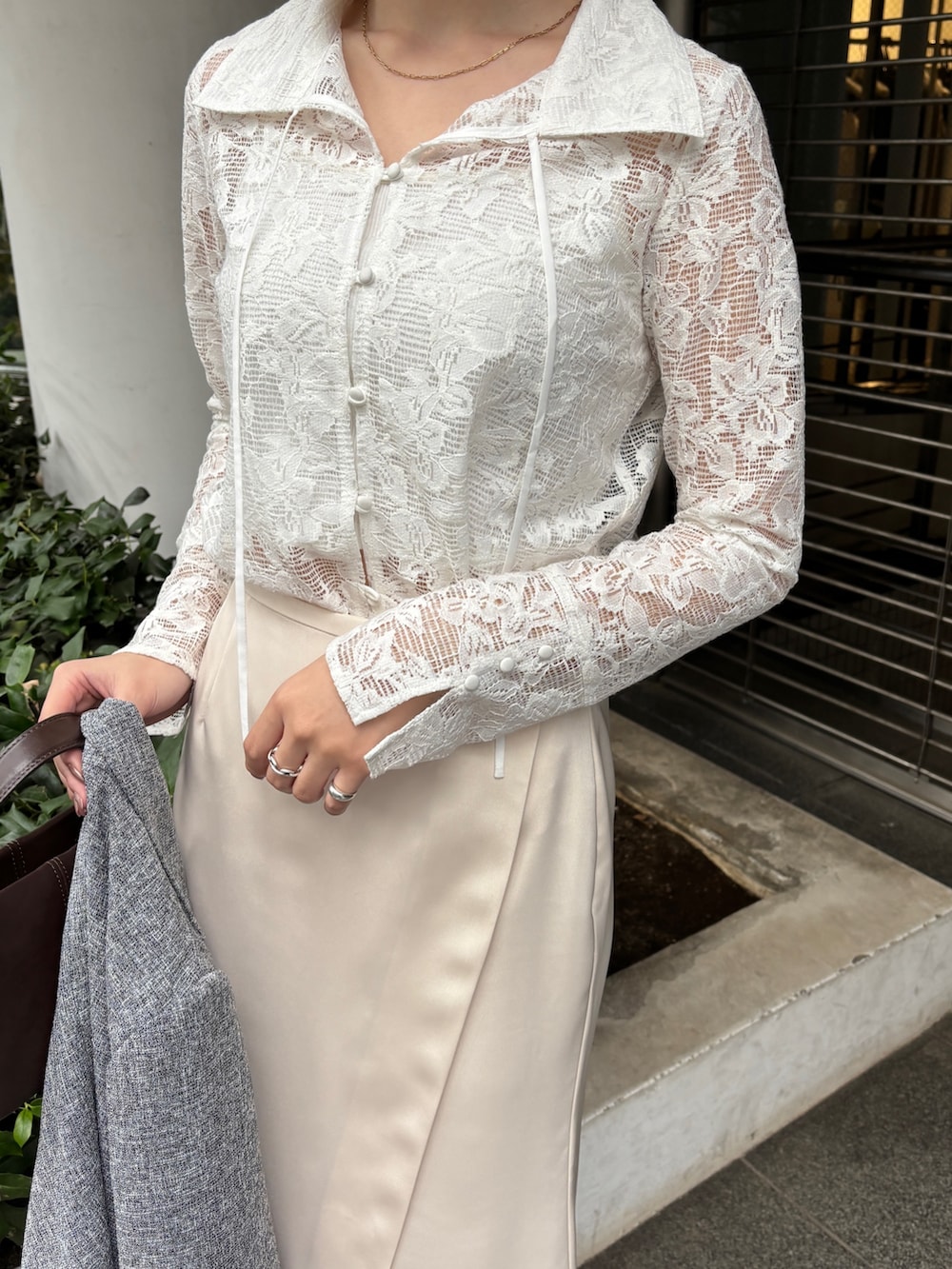 ホワイト系のスカート、ブラック系のテーラードジャケット、シルバー系のパンプスを着用したレディースの冬コーディネートの3枚目の写真