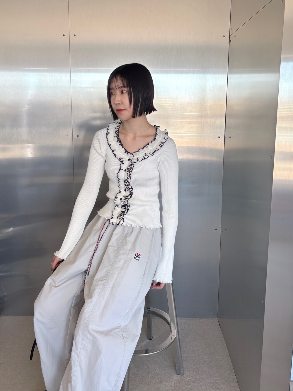 ベージュ系のその他パンツ、ホワイト系のニット/セーター、ブラック系のパンプスを着用したレディースの春コーディネートの4枚目の写真