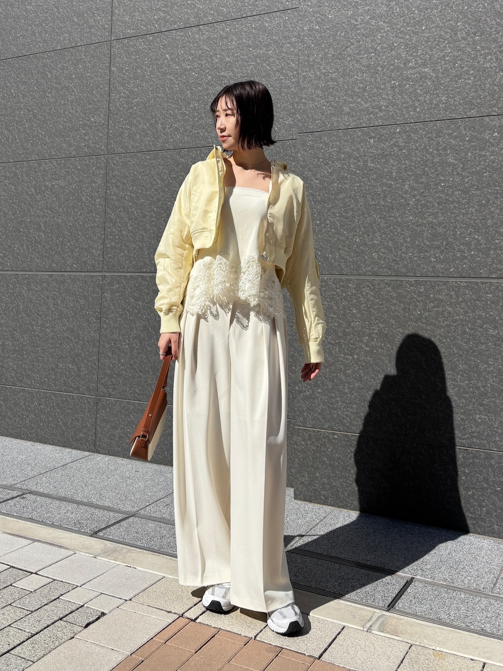 ホワイト系のその他パンツ、ブラウン系のハンドバッグ、イエロー系のブルゾンを着用したレディースの春コーディネートの3枚目の写真