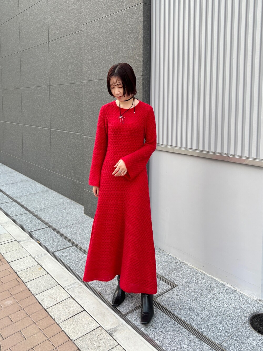 レッド系のワンピース、ホワイト系のチェスターコートを着用したレディースの冬コーディネートの8枚目の写真