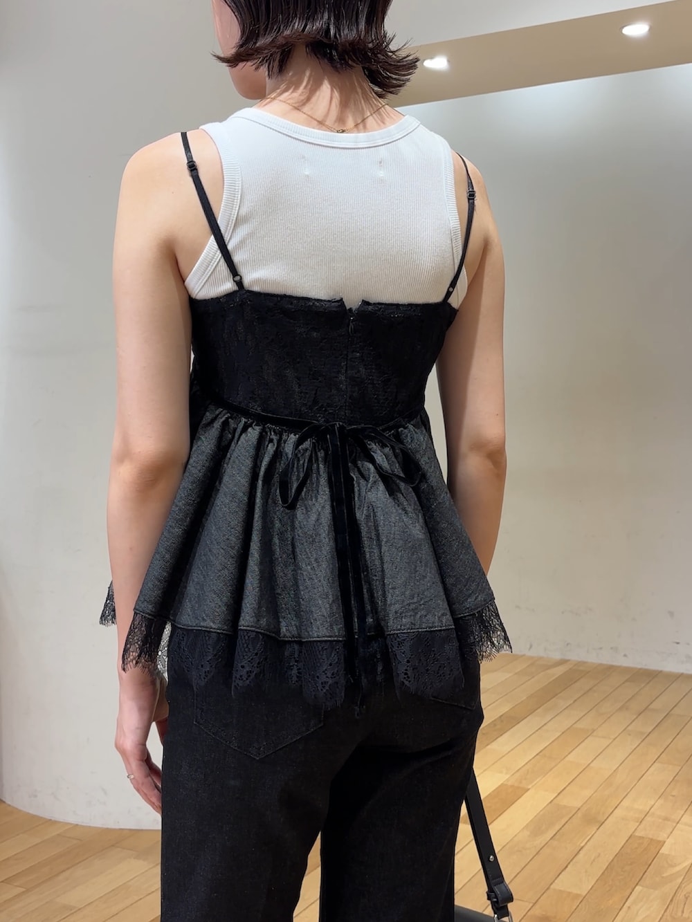 ブラック系のデニムパンツ、シルバー系のパンプス、ホワイト系のタンクトップを着用したレディースの夏コーディネートの7枚目の写真