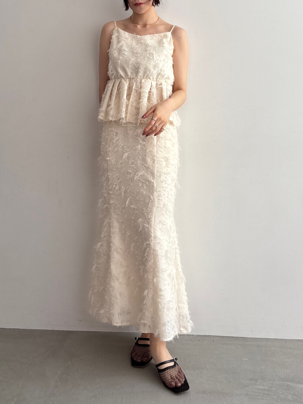 ホワイト系のキャミソール、ホワイト系のスカートを着用したレディースの夏コーディネートの2枚目の写真