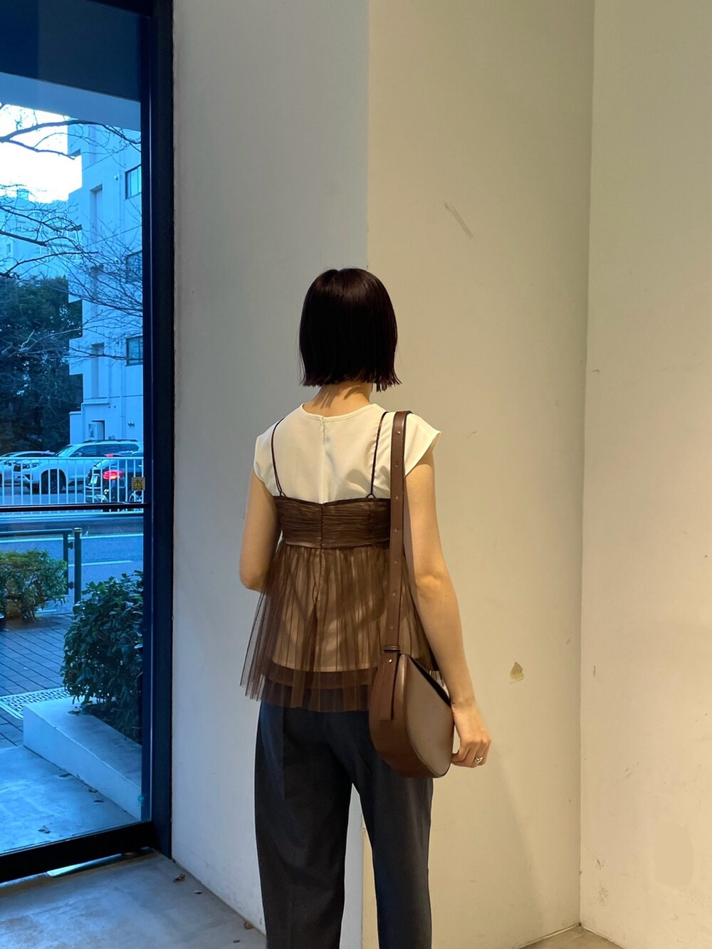 ブラウン系のTシャツ/カットソー、ブルー系のスラックス、ブラック系のサンダルを着用したレディースの春コーディネートの6枚目の写真